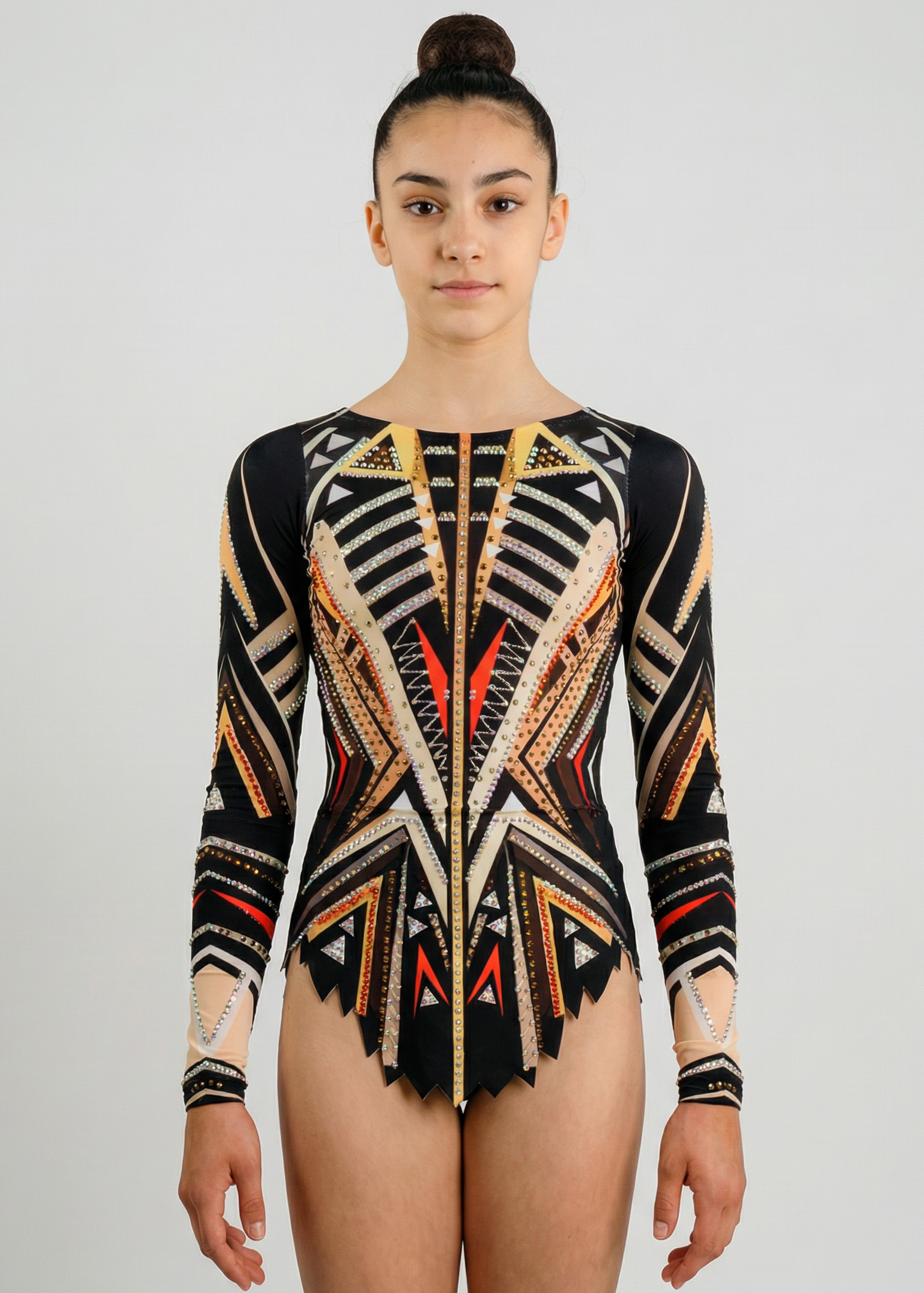 Maillot de gimnasia rítmica en negro, beige y naranja con mangas largas, pedrería y patrones geométricos creando un estilo impactante.
Maillot de gimnasia rítmica en tonos negros y beige con detalles naranjas, pedrería y diseño geométrico de apariencia dinámica.
Maillot de gimnasia rítmica visto por la espalda en negros y beige con pedrería y motivos geométricos formando un estilo marcado.