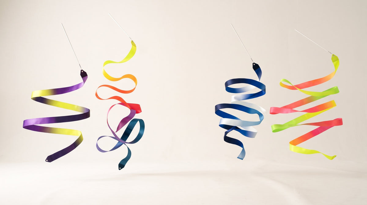 Colourful VINKOVA rhythmic gymnastics ribbons forming suspended spirals against a light background.