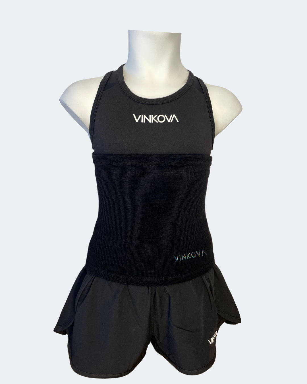 Ceinture Vinkova, coloris noir, à la taille d’un mannequin en tenue noire.