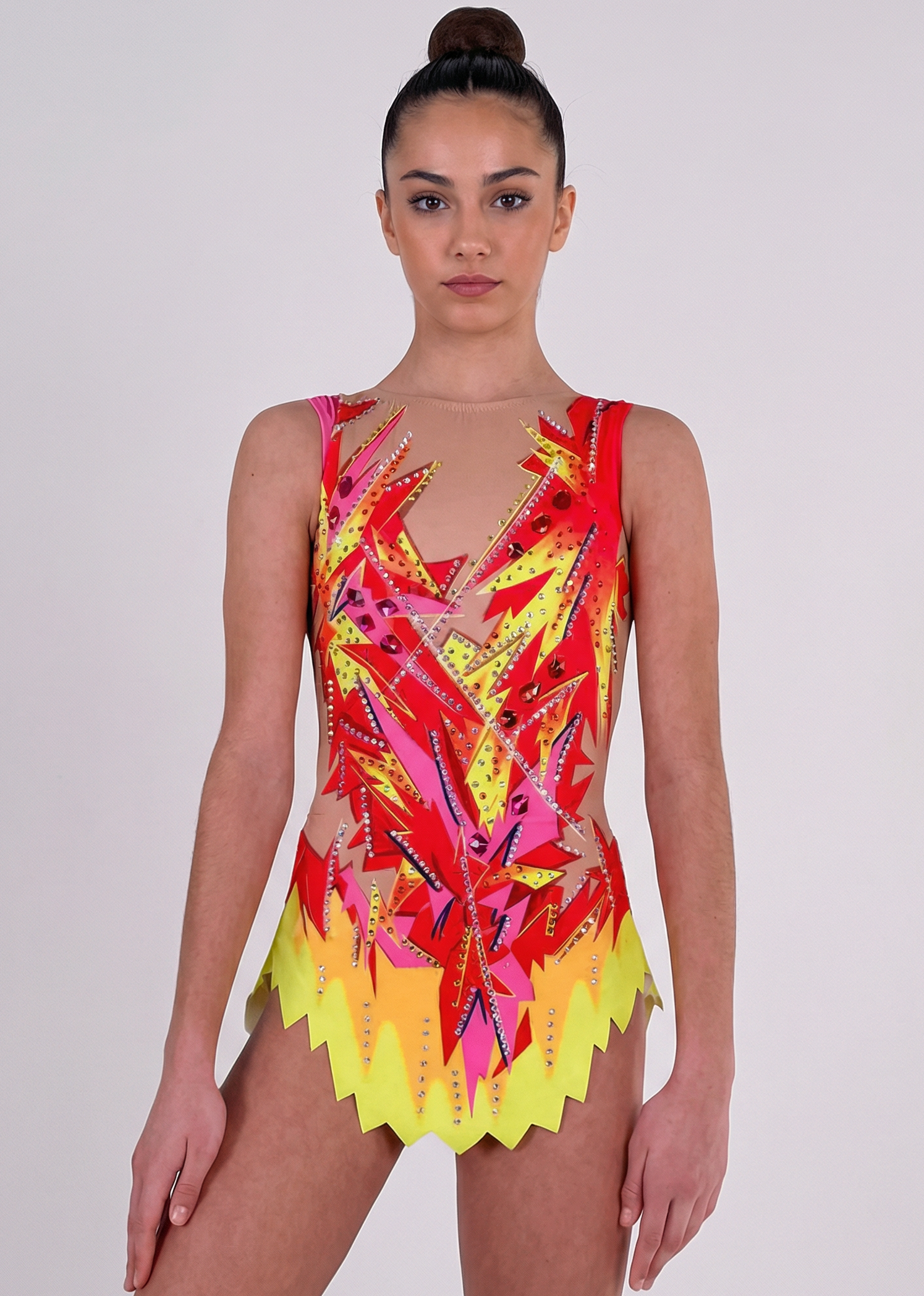 Maillot de gimnasia rítmica en rojo, rosa y amarillo con pedrería, transparencias simuladas y motivos flameados creando un estilo vibrante.
Maillot de gimnasia rítmica color claro con rojos intensos, detalles amarillos y rosas, pedrería brillante y diseño flameado de aspecto dinámico.
Maillot de gimnasia rítmica visto por la espalda en base clara con rojos, rosas y amarillos, pedrería y trazos flameados fluidos.
