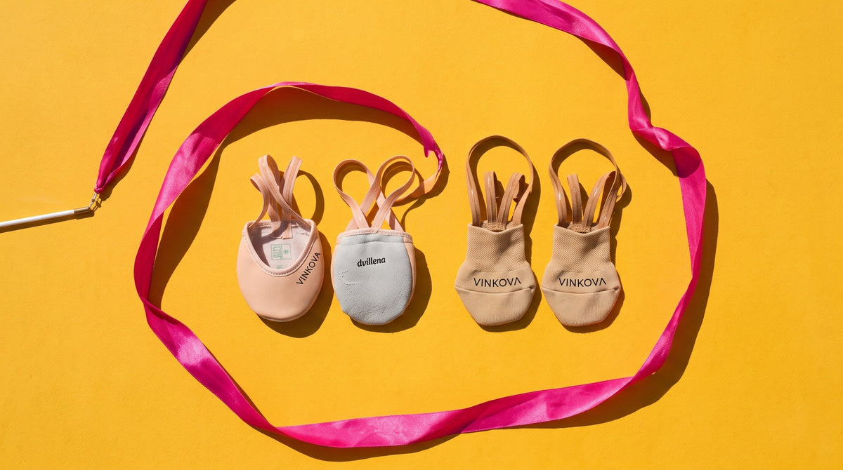 Dvillena and VINKOVA rhythmic gymnastics toe shoes in different shades beside a fuchsia ribbon on a yellow background.