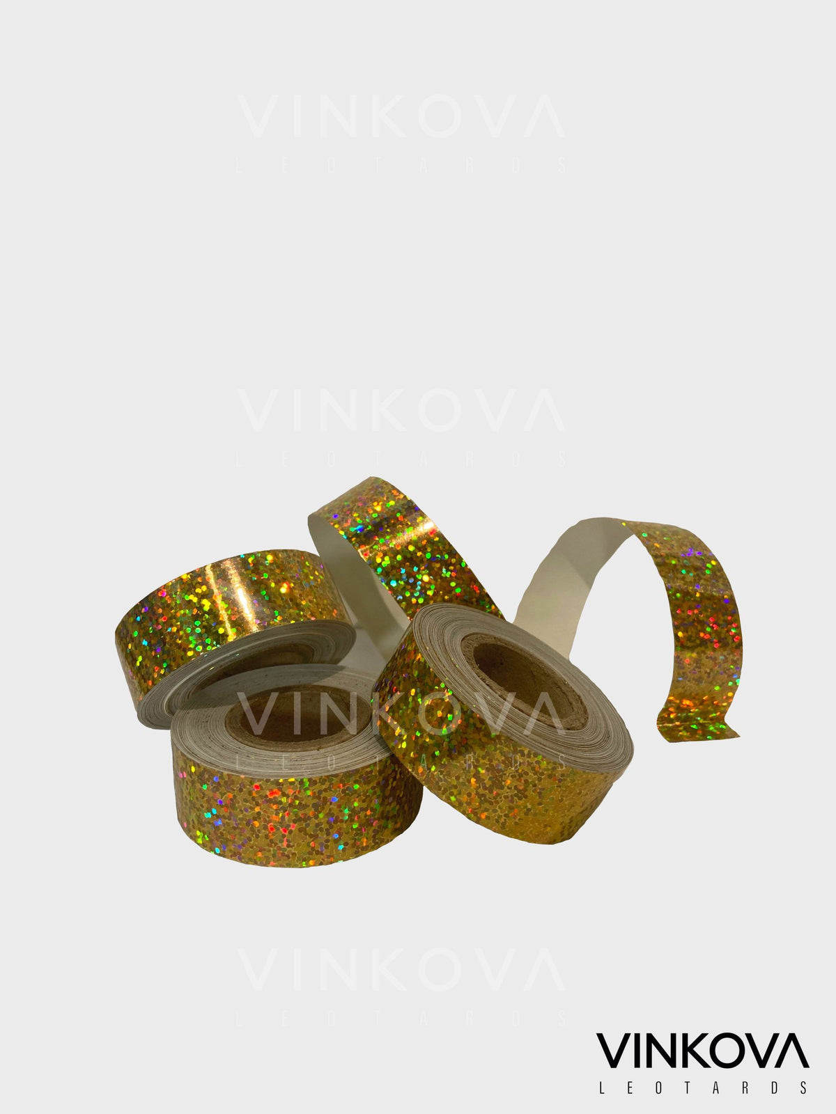 Cinta adhesiva Vinkova para aparatos de gimnasia rítmica, con chispas, dorado, en rollos y tiras desplegadas.