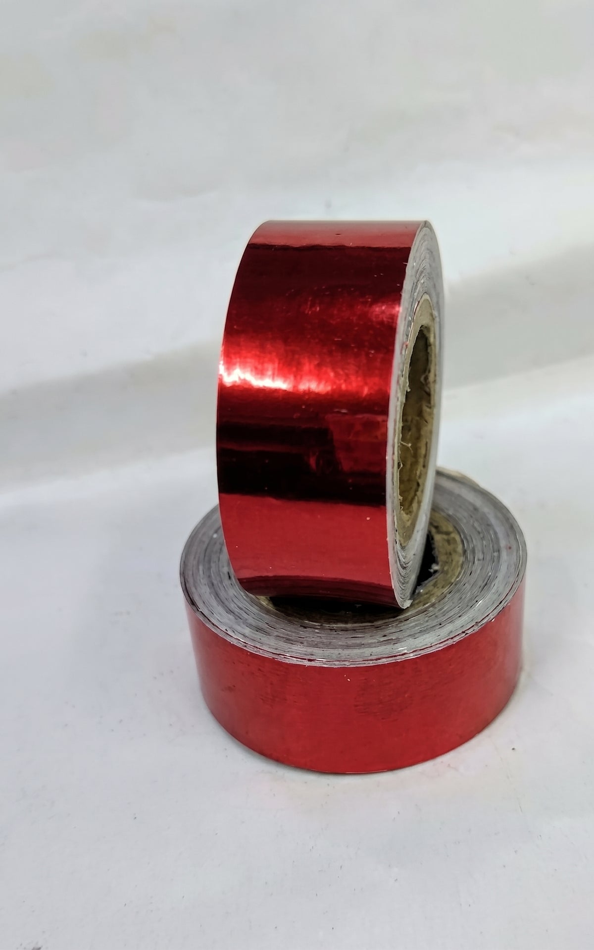 Cinta adhesiva Vinkova para aparatos de gimnasia rítmica, efecto espejo, rojo, en rollos superpuestos.