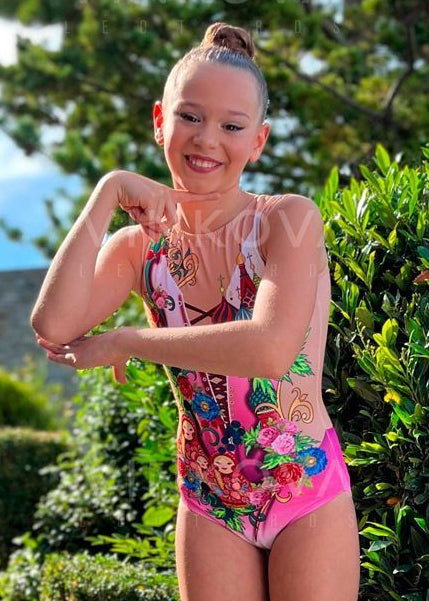 Maillot rítmico elástico con estampado de catedral rusa, rosas y muñecas tradicionales sobre fondo degradado.