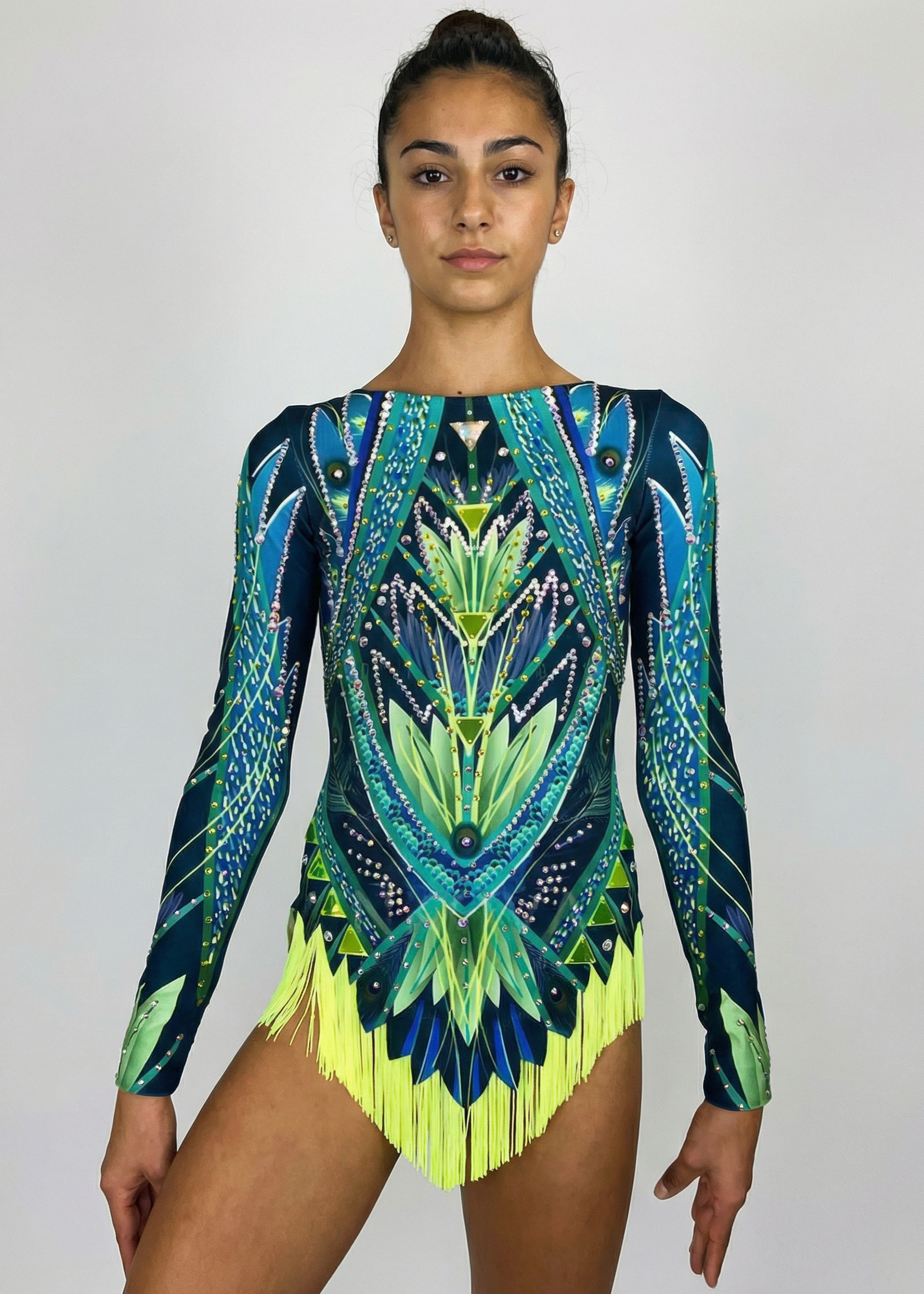 Maillot de gimnasia rítmica en verdes y azules con mangas largas, pedrería abundante y flecos amarillos creando un estilo geométrico vibrante.

Maillot de gimnasia rítmica en tonos verde lima y azul, con pedrería, simetrías marcadas y flecos amarillos aportando un acabado dinámico.

Maillot de gimnasia rítmica visto por la espalda en verdes y azules, con pedrería, mangas largas y diseño geométrico fluido con flecos amarillos.