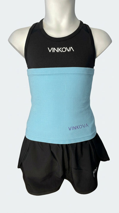 Vinkova waist warmer, colour: sky blue, on a mannequin wearing a black outfit.