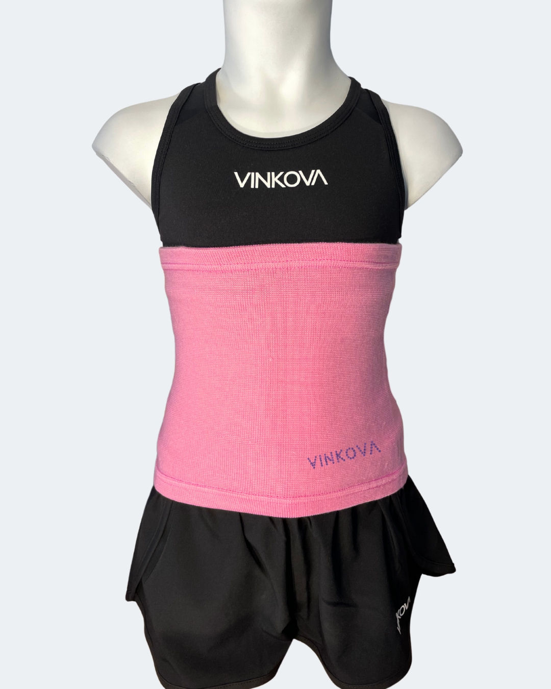 Faja Vinkova, color rosa, cubriendo la cintura de un maniquí con conjunto negro.