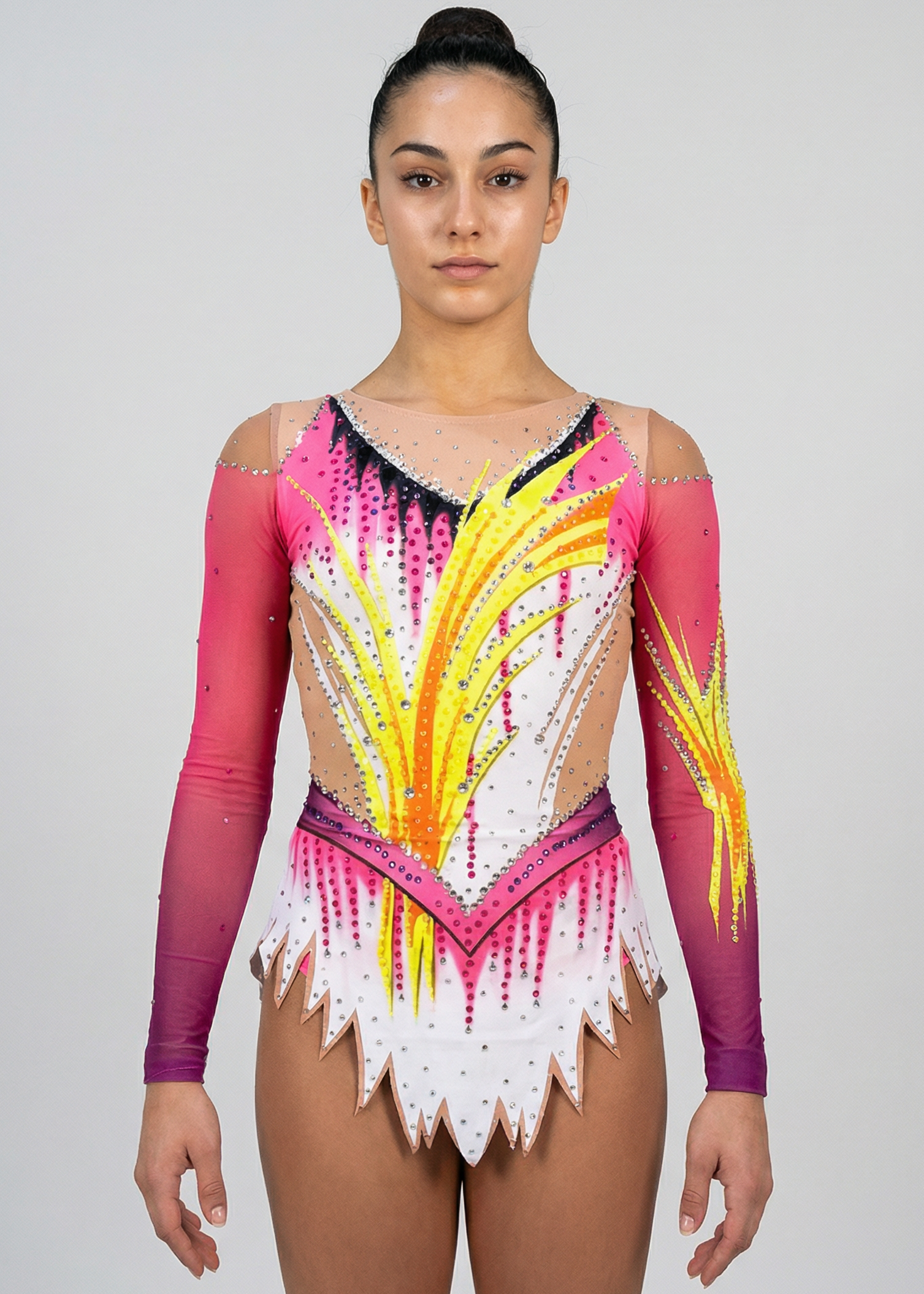 Maillot de gimnasia rítmica en blanco, rosa y amarillo con mangas degradadas, pedrería abundante y motivos flameados creando un estilo vibrante.

Maillot de gimnasia rítmica color claro con rosas intensos, detalles amarillos, pedrería brillante y diseño flameado que aporta un efecto dinámico.

Maillot de gimnasia rítmica visto por la espalda en blanco y rosa con pedrería, degradados y motivos amarillos formando un estilo fluido.