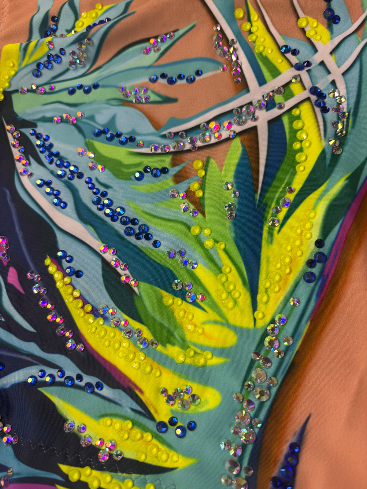 Gros plan de Dalí avec des pierres bleues, jaunes et irisées sur les traits turquoise et vert citron.