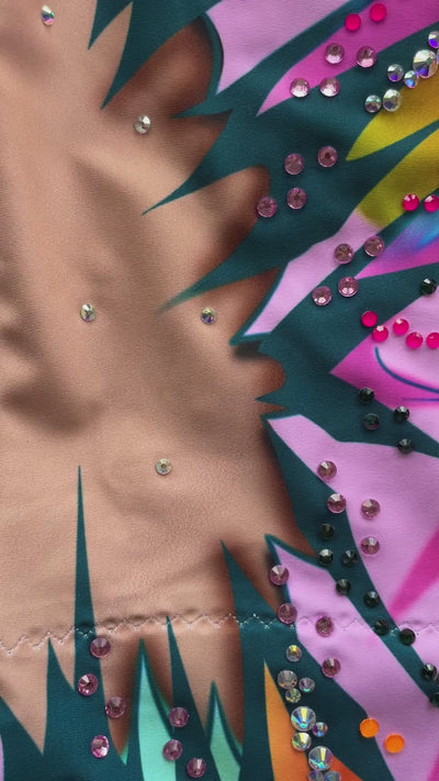 Maillot profesional elástico con manga degradada naranja a violeta y brillantes.